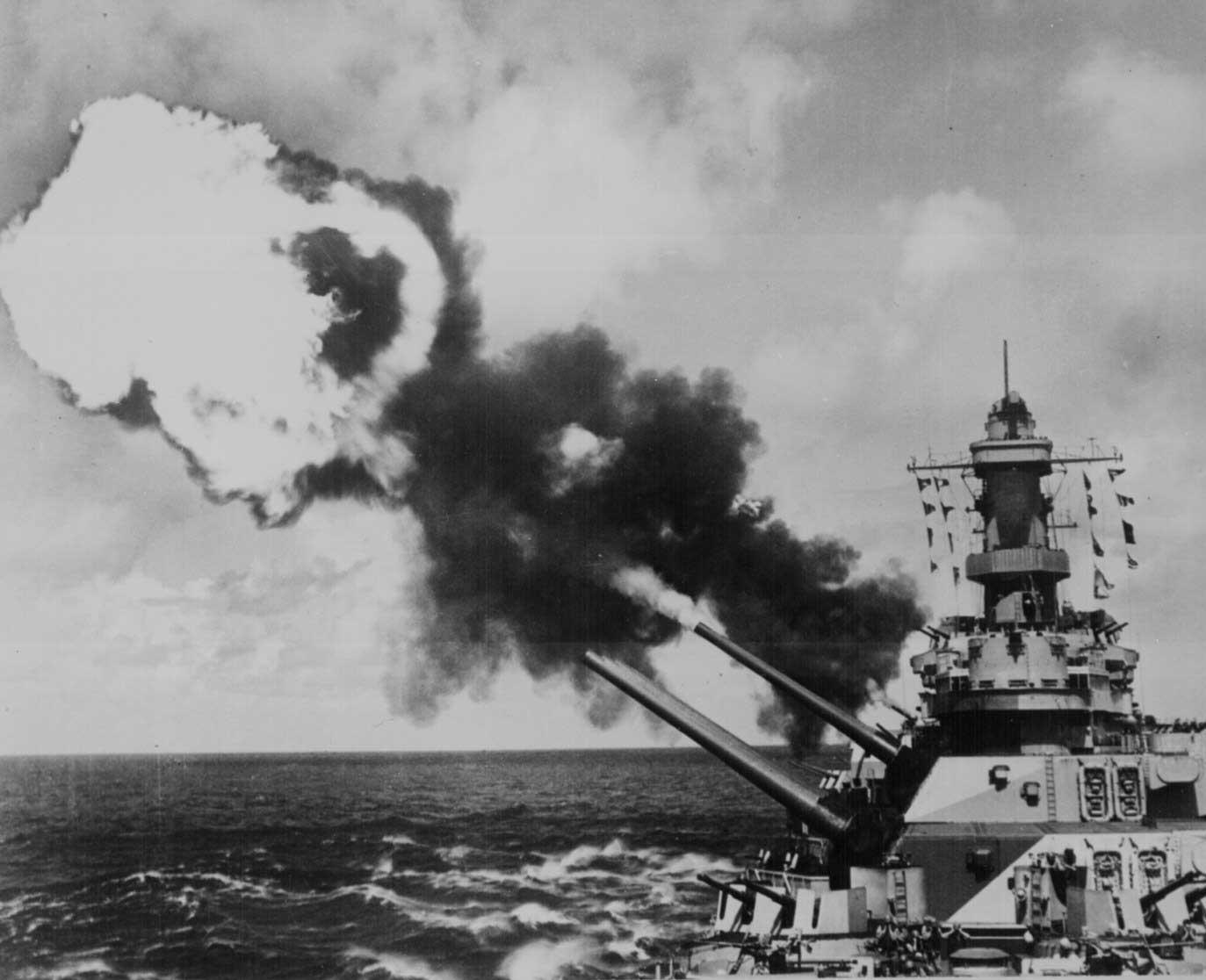 Battleship Iowa firing her 16-inch primary guns during a drill in the Pacific Ocean, circa 1944