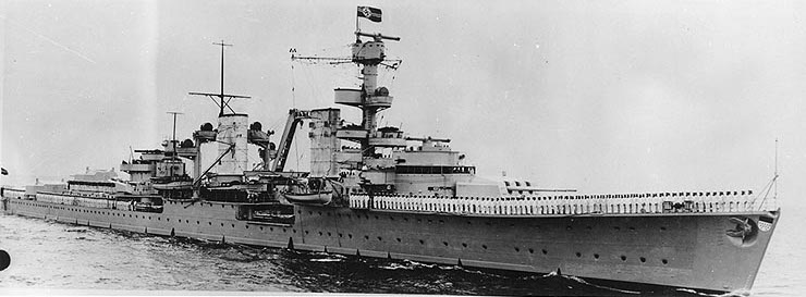 Light cruiser Köln underway with her rails manned, circa 1936; note the heraldic shield mounted on her bow