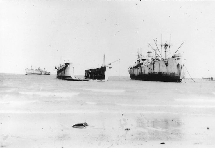 Liberty Ship IX-229 Inca/IX-227 Gamage aground in Buckner Bay, Okinawa, Oct 1945; note a floating drydock nearby and another Liberty Ship in distance