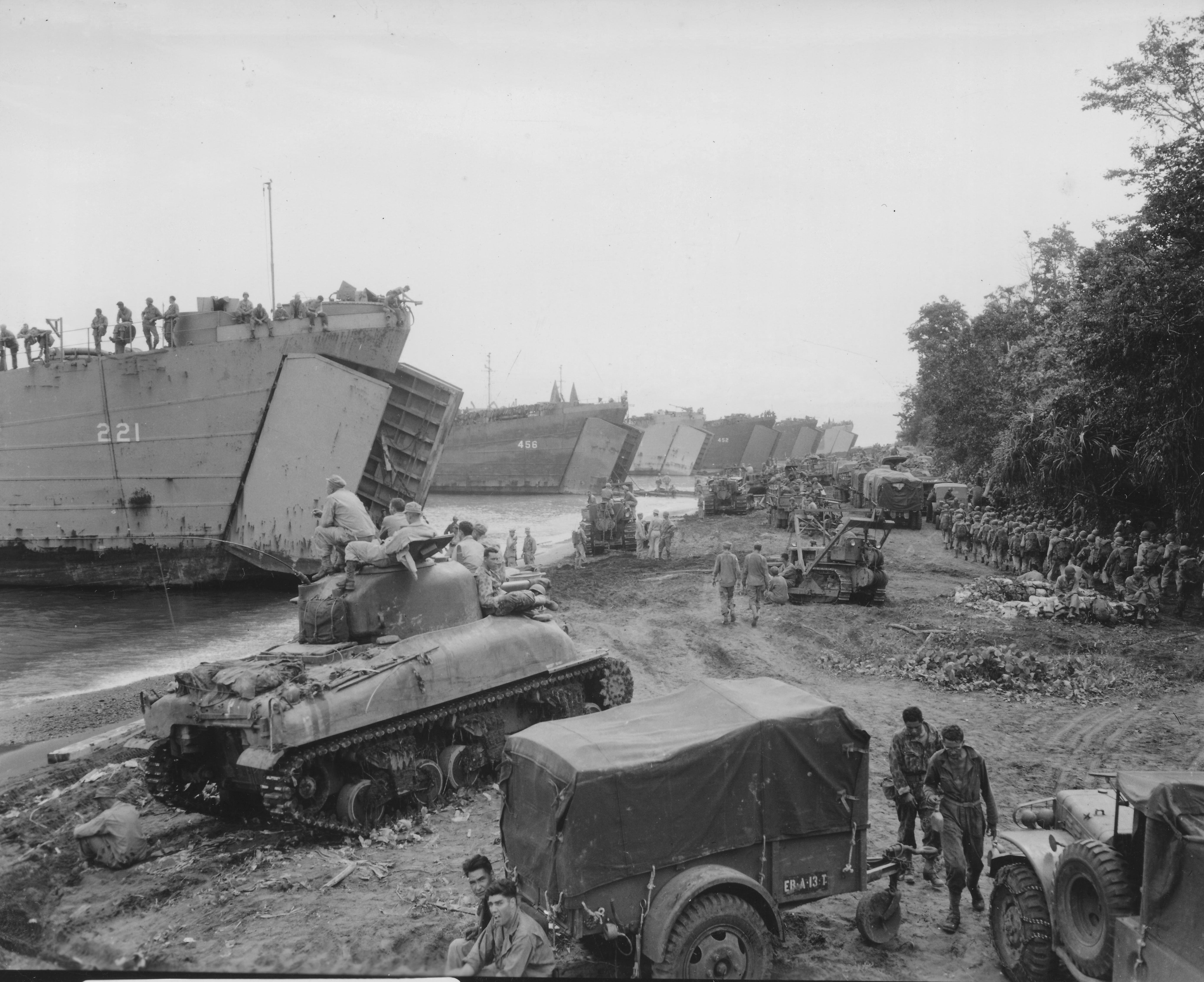 Six US Navy LSTs loading men and equipment during a practice landing near Lae, New Guinea, 10 Apr 1944; note M4 Sherman tank, Dodge Weapons Carrier, GMC CCKW 2 1/2-ton 6x6 trucks