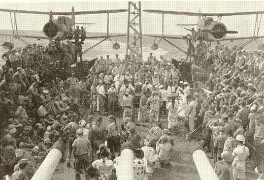 Line crossing ceremony aboard light cruiser USS Montpelier, circa 30 Dec 1942; note SOC-1 aircraft in background