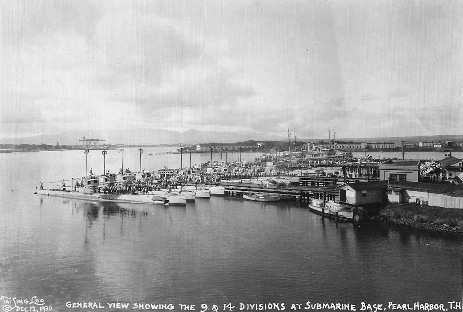 20 R-class submarines of US Navy Submarine Divisions 9 and 14 at Pearl Harbor, US Territory of Hawaii, 12 Dec 1930. Note the repair piers and floating crane YD-25 in the distance.