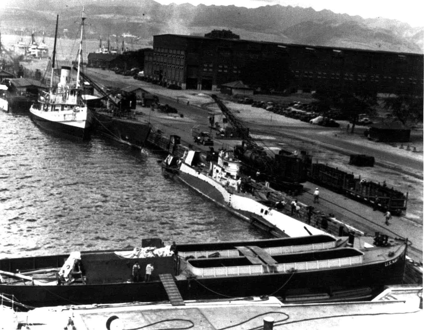 USS S-34 tied up to wharf in Pearl Harbor, US Territory of Hawaii, late 1930s; note railcar carrying new batteries for S-34, and a Balao-class submarine moored nearby