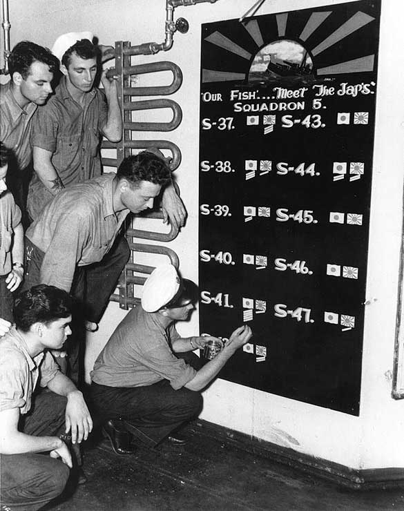 Men of US Navy Submarine Squadron 5 keeping score of sinkings aboard USS Griffin, 7 Jan 1943; the squadron operated out of Brisbane, Australia