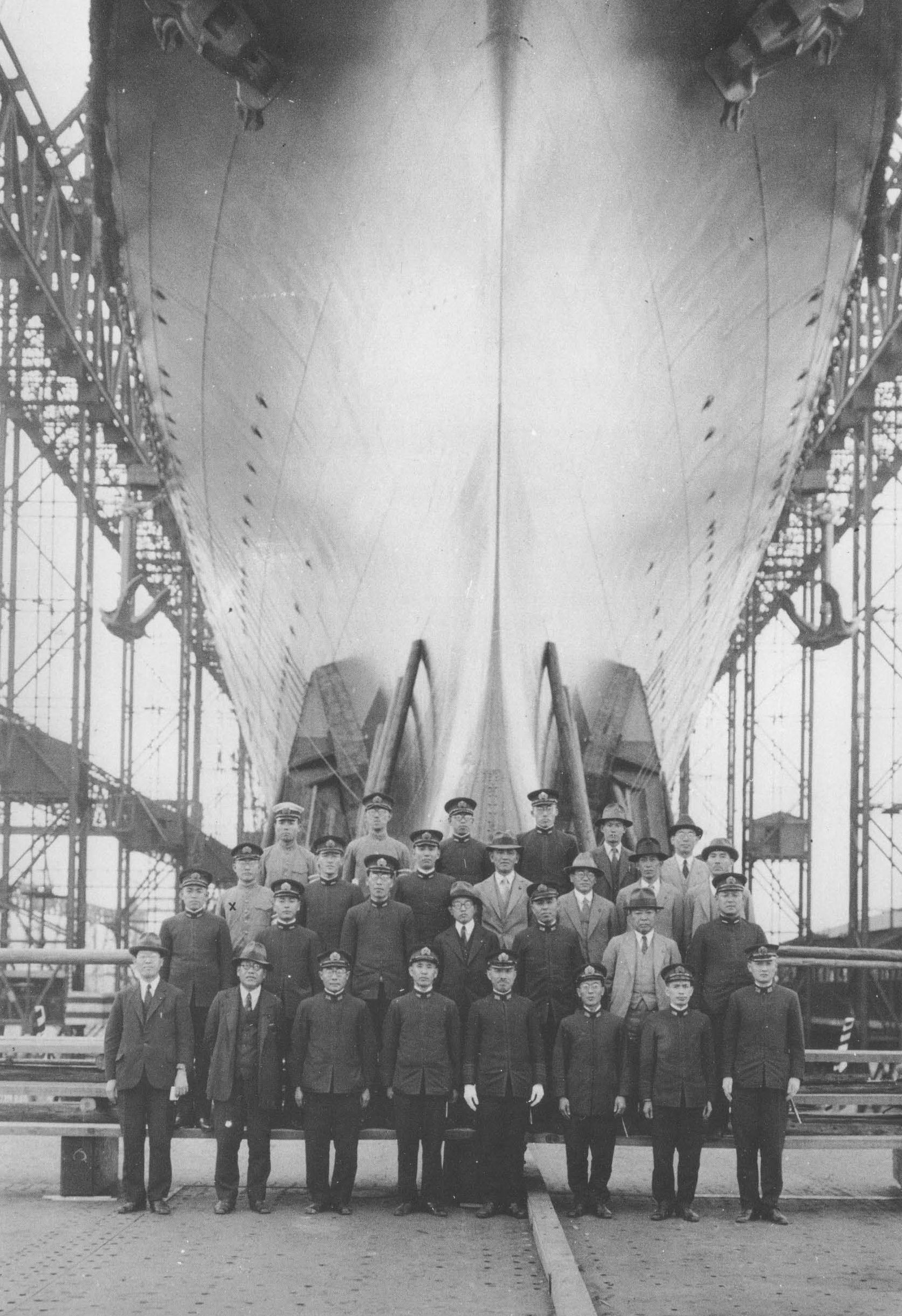 The chief shipbuilders of carrier Shokaku posing with the hull of the ship two days prior to launching, Yokosuka, Japan, 30 May 1939