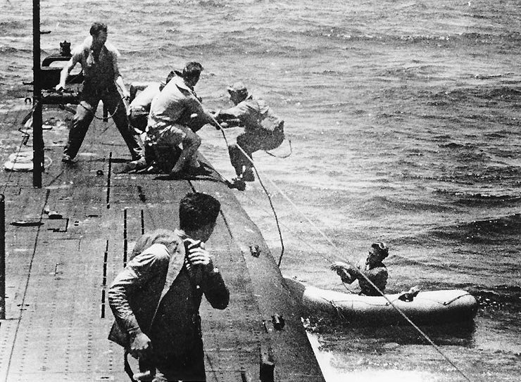 Crew of USS Tang taking aboard airmen of downed OS2U Kingfisher aircraft from USS North Carolina, off Truk, Caroline Islands, 1 May 1944
