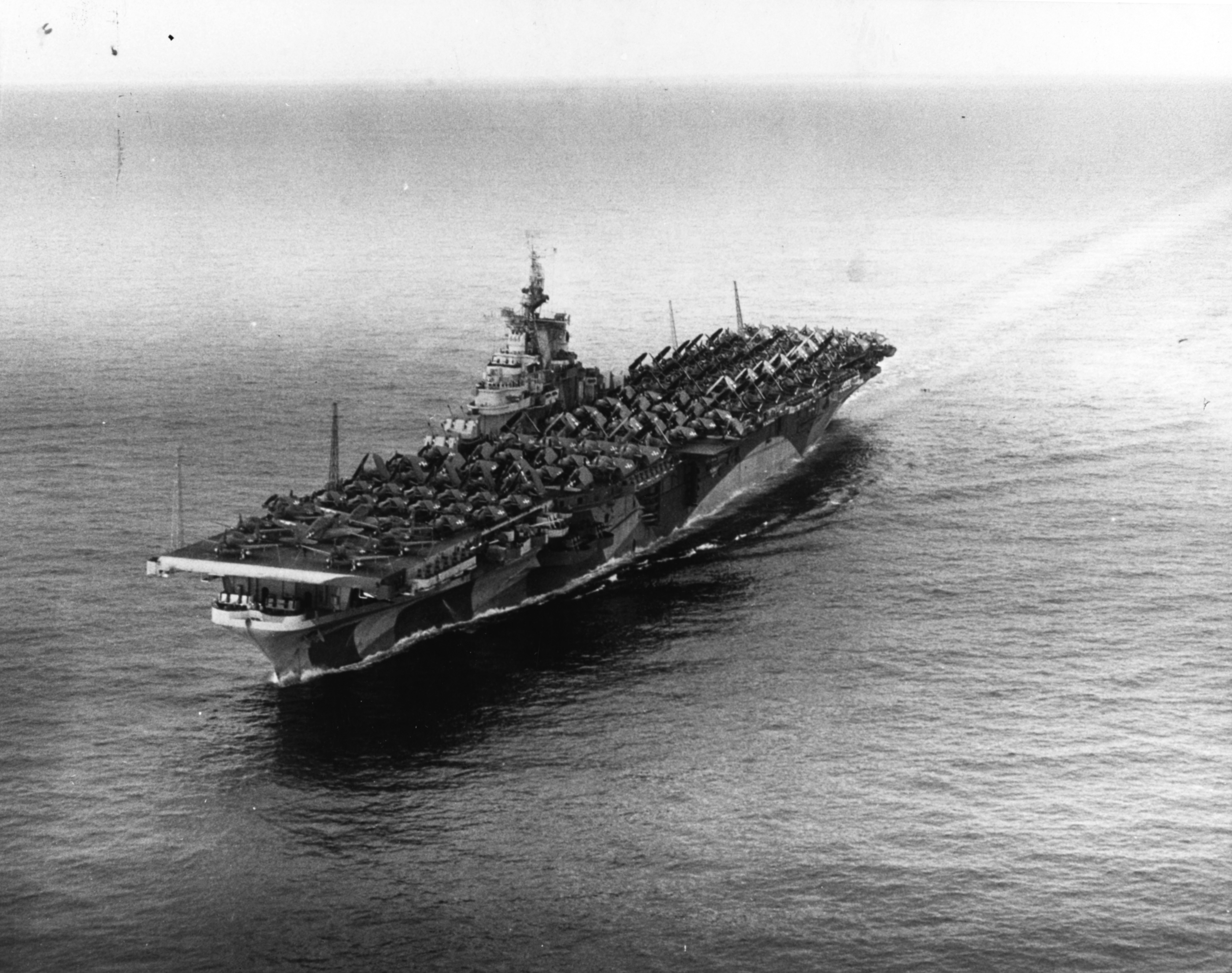 Carrier Ticonderoga off San Diego, California, United States, 16 Sep 1944; note extra aircraft loaded on deck destined for Hawaii, and camouflage pattern Measure 33 Design 10a. Photo 1 of 2.