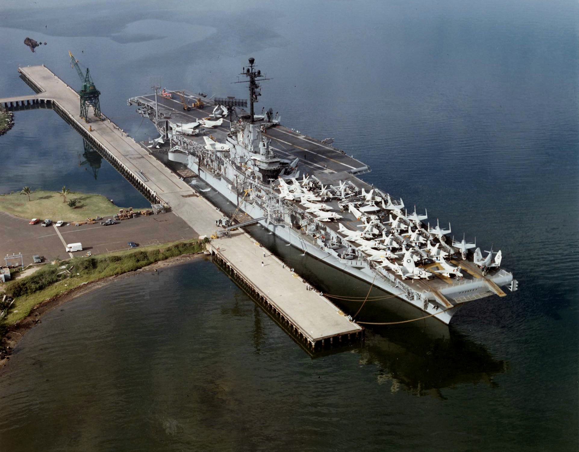 USS Ticonderoga, Pearl Harbor, Hawaii, United States, 1962. Note the capsized hulk of USS Utah in the upper left.
