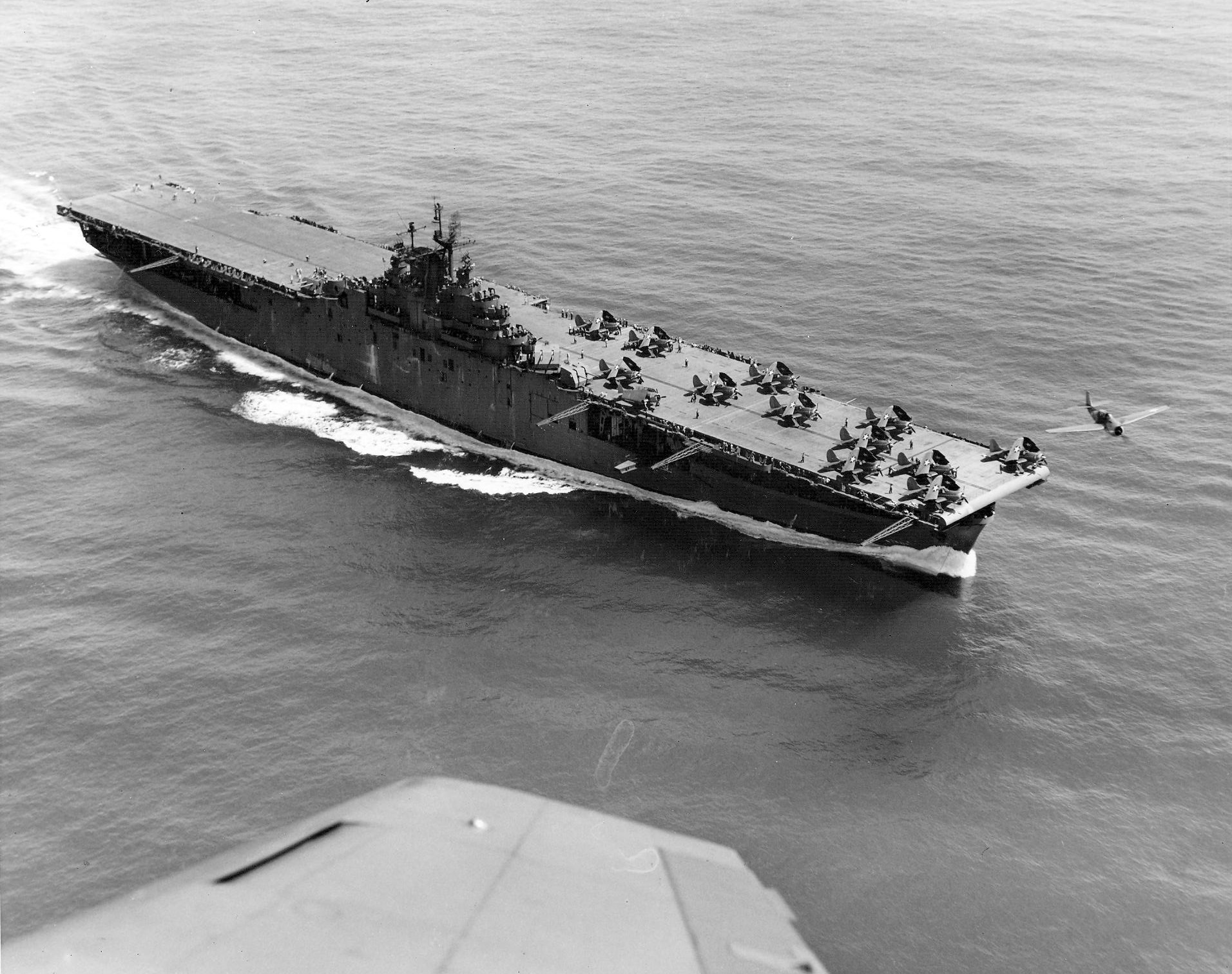 USS Yorktown (Essex-class; CV-10) circa mid-1943, with a TBF Avenger flying over her bow