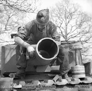 Soldier maintaining the 29cm Petard spigot mortar on a Churchill AVRE of 79th Squad, 5th Assault Regt, Royal Engineers, UK 3rd Infantry Division, 29 Apr 1944; note 40-lb bomb on right
