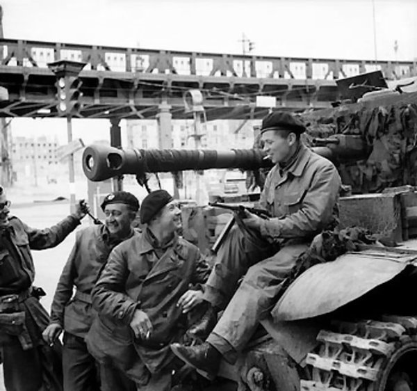 Cromwell tank crew of C Squadron, 5th Royal Tank Regiment in Hamburg, Germany, 4 May 1945; the man sitting on the tank was a Russian former POW who had been fighting alongside the crew