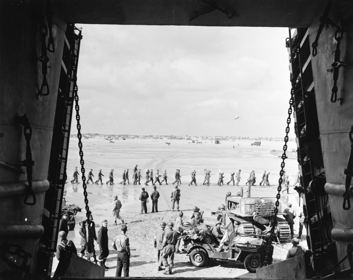 Jeep bringing casualties to a LST for evacuation, Utah Beach, Normandy, France, 13 Jun 1944; note line of German POWs