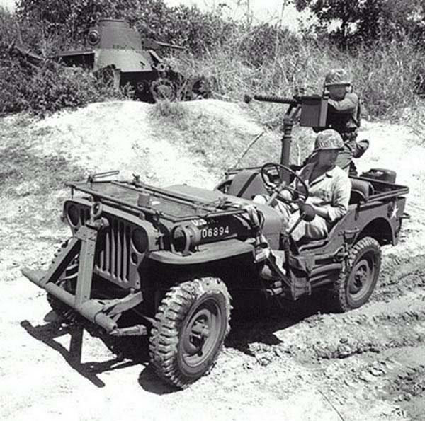 Jeep mounted with a Browning M1919 machine gun, somewhere in the Pacific, 1943-1945; note hulk of Japanese Type 95 Ha-Go light tank