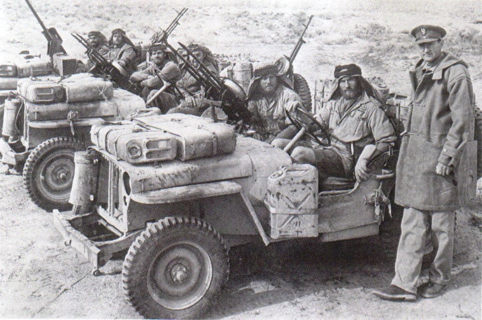 A close-up of a British heavily armed patrol of L Detachment SAS in their jeeps, just back from a three month patrol, 18 Jan 1943; note twin-mounted Vickers K machine guns and F-S dagger; photo 2 of 3