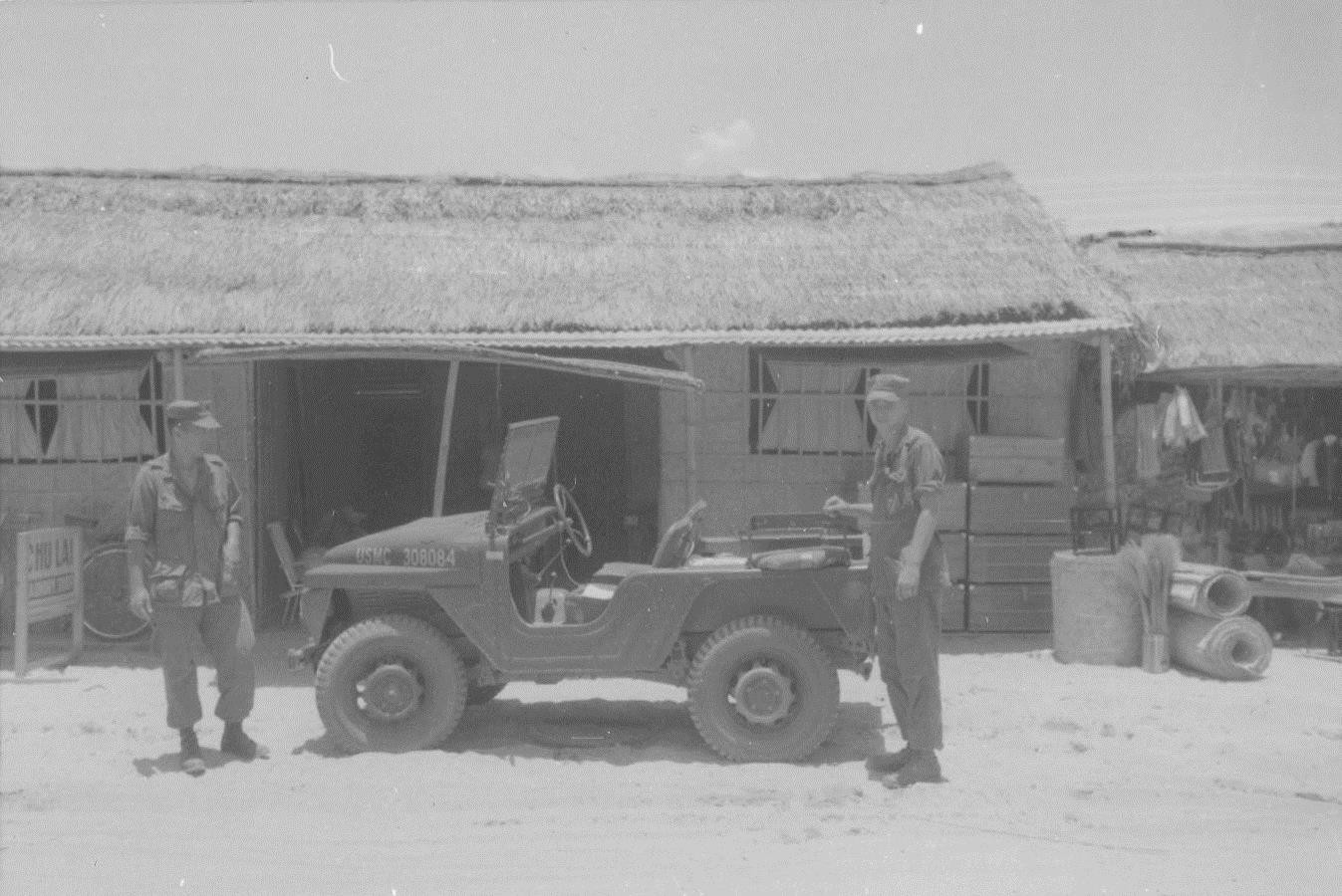 US Marine Sergeants Asato and Carlson with a Jeep in the village of An Ton, Vietnam, 1966