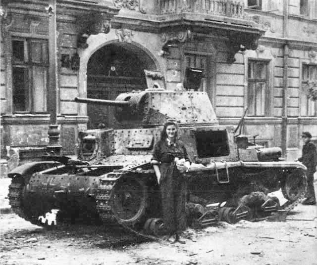 Polish resistance courier Alina Nawrocka posing before a disabled Italian-made PzKpfw 736(i) tank in Warsaw, Poland, 22 Aug 1944