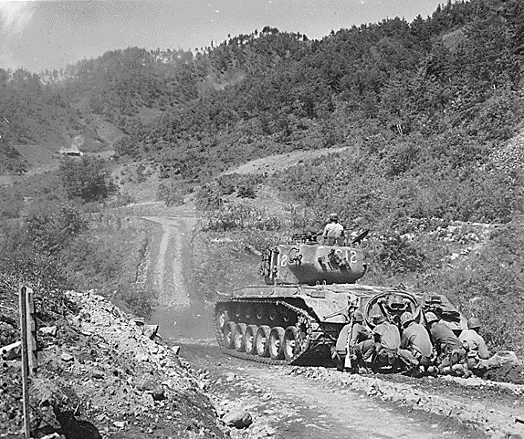 US Marines crouching behind a M26 Pershing tank, near Hongcheon, Korea, 22 May 1951