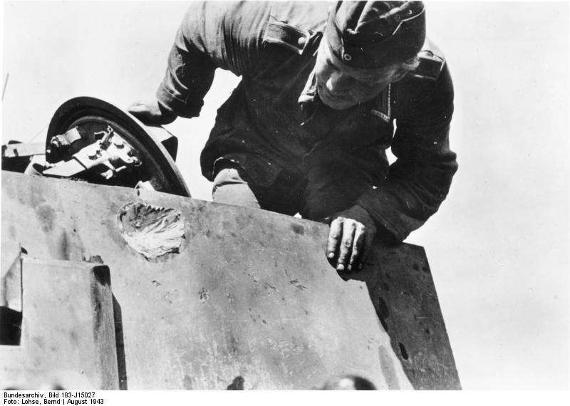 German tanker inspecting damage on the surface of a Tiger I heavy tank caused by a large caliber gun, Russia, Aug 1943