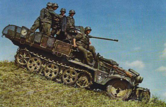 A German SdKfz. 10 halftrack vehicle mounting a 20-mm anti-aircraft gun driving down a hill with its crew aboard, date unknown