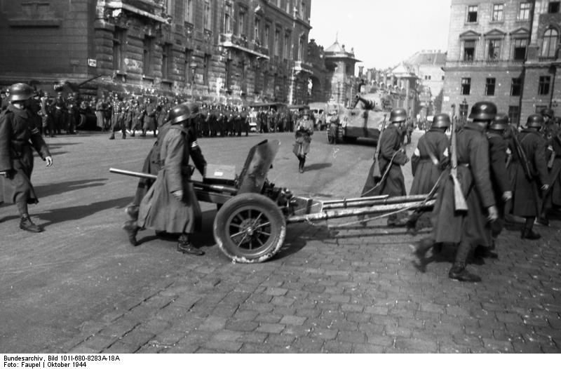 Hungarian Arrow Cross personnel with a 40mm MAWAG anti-tank gun M1940, Budapest, Hungary, Oct 1944; note 43M rifles and Tiger II tank of German 503rd Heavy Panzer Battalion in background