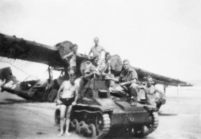 Australian soldiers posing with a captured Japanese Type 92 tankette and wrecked No. 42 Squadron RAAF Catalina aircraft, Balikpapan, Borneo, 1945