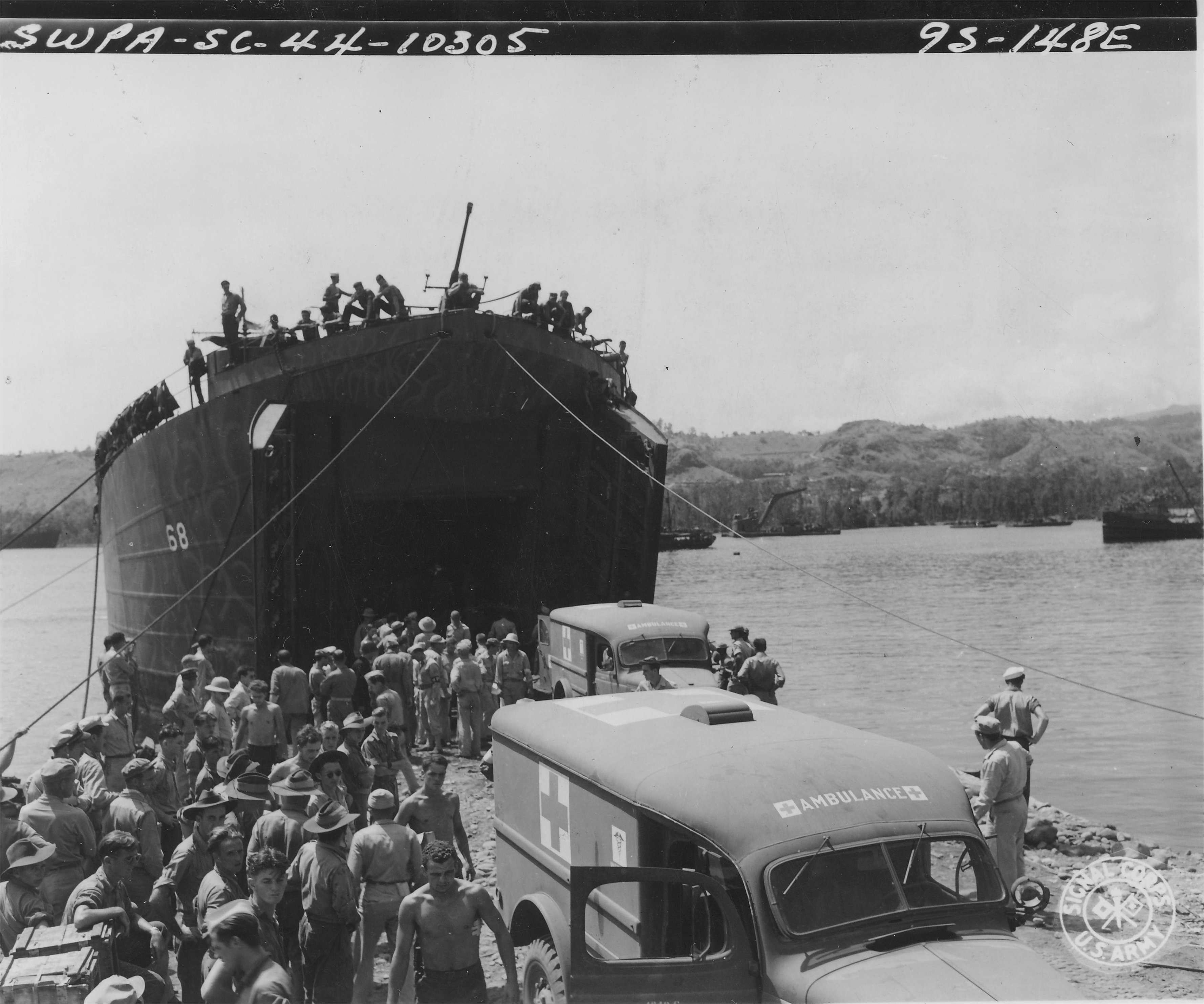 LST-68 at Oro Bay, New Guinea, with US Marine casualties returning from Cape Gloucester, New Britain being assisted into WC54 ambulances, 8 Jan 1944