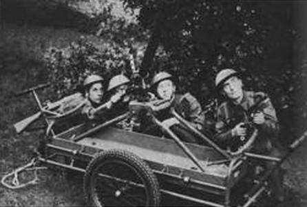 British Home Guard personnel posing with a Northover Projector with tripod mounted on a hand cart, circa early 1940s
